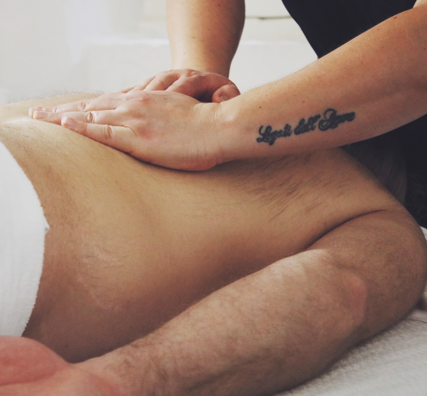 Sandra masseert de rug van een klant op de massagetafel